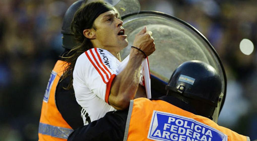 Matias Almeyda trattenuto a fatica dalla Polizia mentre fa il gesto di baciare la maglia sotto la curva dei tifosi del Boca Juniors. Foto: Archivo/Telam.